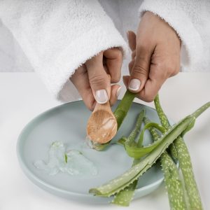 close up hands taking aloe vera gel 300x300 1